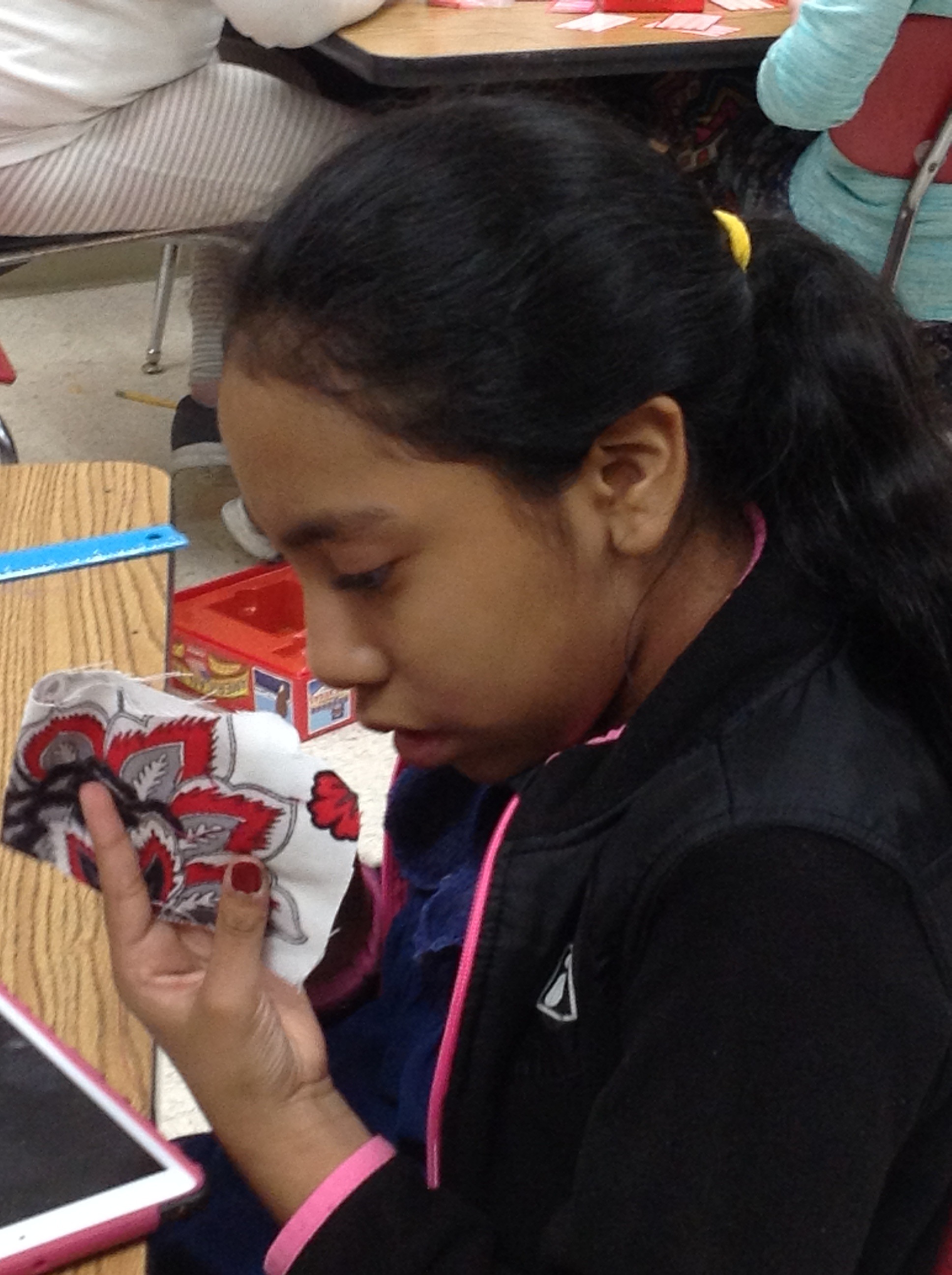 A Cherokee Elementary School student closely examines her work for Teresa Zimmer's service-learning project.